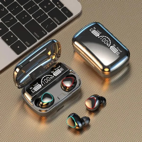 Wireless earbuds with charging case on a textured surface next to a laptop.